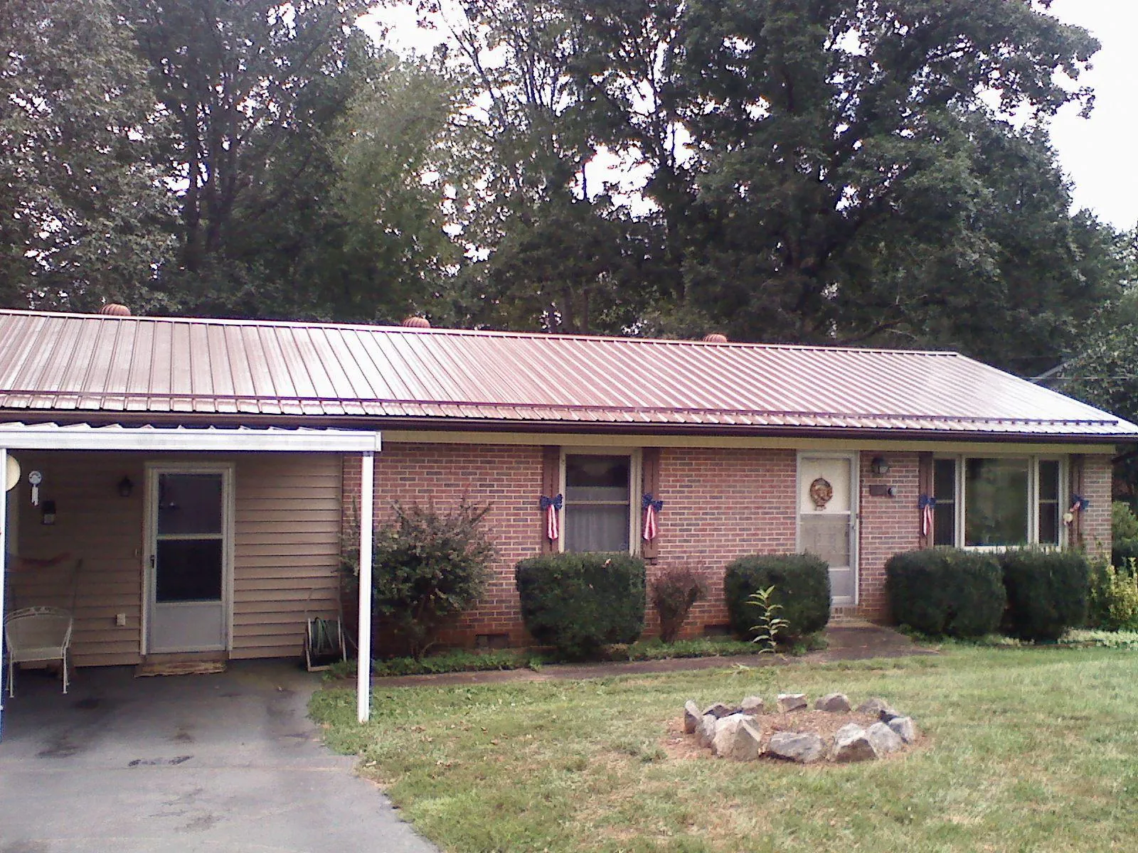Bronze metal roof and carport on a brick ranch home — Roof Repair work by our crew in Rock River